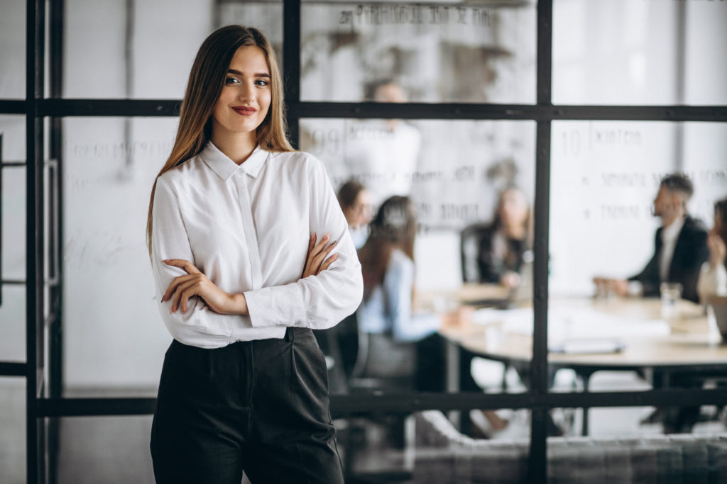 Femme d'affaires au bureau femme-debout-bras-croisés-noir-blanc-devant-vitre